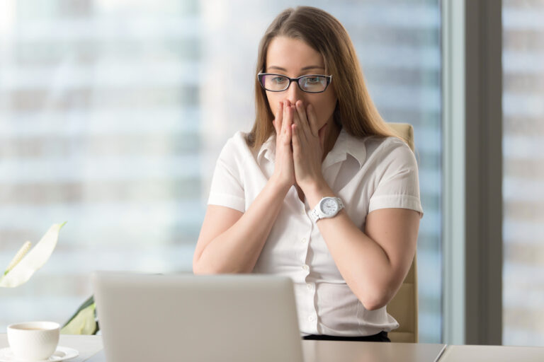 Small business owner surprised by the difference between profit and cash flow while reviewing her financial reports on a laptop.