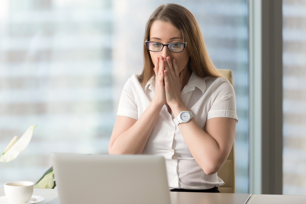 Small business owner surprised by the difference between profit and cash flow while reviewing her financial reports on a laptop.